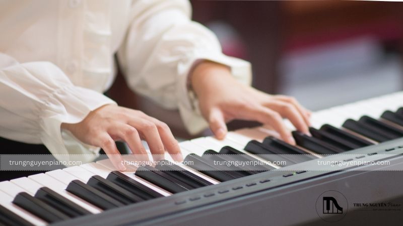 Ngồi thẳng lưng, hai tay đưa về phía trước, khuỷu tay ngang tầm phím đàn