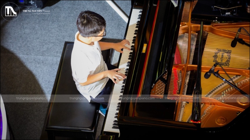 Con trai học piano có nên không? Giải mã định kiến & khám phá lợi ích vàng 4 Bé trai tự tin biểu diễn piano trước đám đông