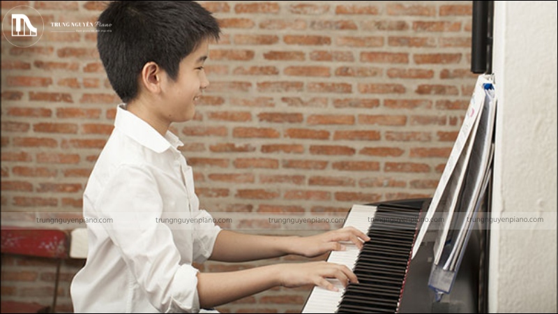 Con trai học piano có nên không? Giải mã định kiến & khám phá lợi ích vàng 5 Bé trai đang chìm đắm trong âm nhạc