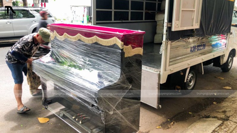 Đội ngũ nhân viên đang vận chuyển đàn piano bằng xe chuyên dụng