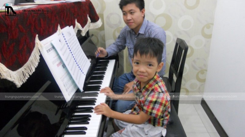 Ngân sách 100 triệu nên chọn Grand Piano cũ hay Upright mới cao cấp? 9 Một học viên nhỏ tuổi đang vui vẻ học đàn trên cây Upright Piano