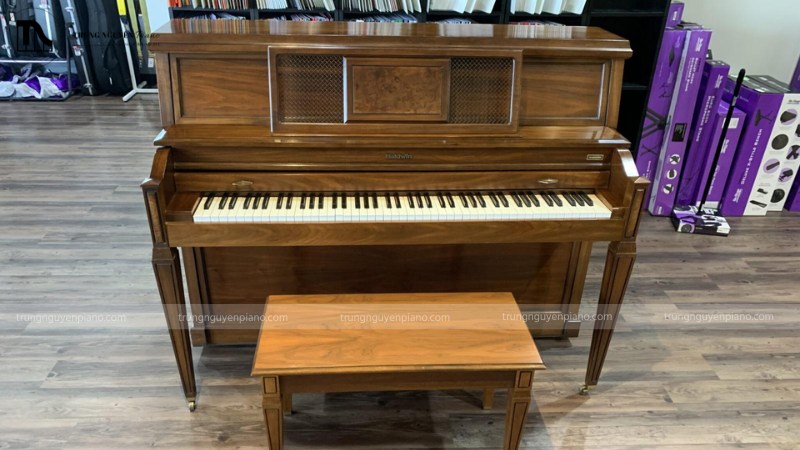 Một cây đàn piano upright đang được trưng bày gọn gàng trong showroom nhạc cụ