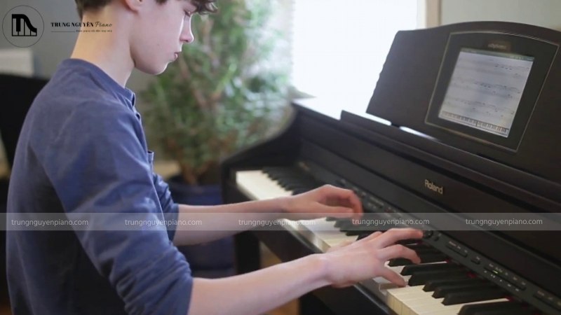 Bàn tay của một em bé đang đặt trên các phím đàn piano điện