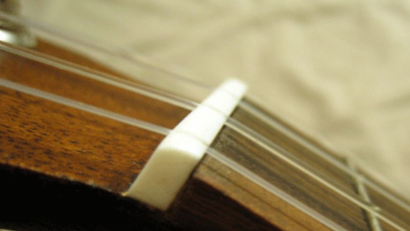 Lược đàn ukulele với các rãnh cố định khoảng cách dây, ảnh hưởng đến độ cao dây