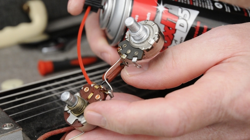 Xịt dung dịch Contact Cleaner vào khe hở của núm vặn guitar điện