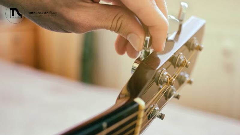 Dùng tay quay hoặc tay không, vặn các chốt khóa đàn