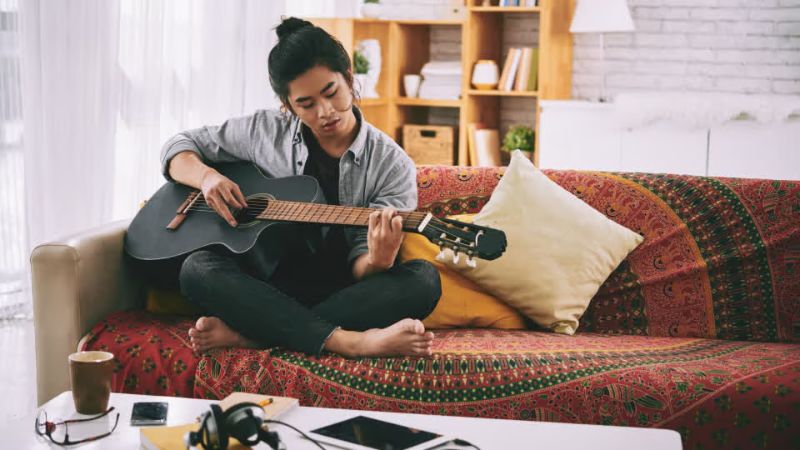 Người chơi guitar thưởng thức âm thanh đúng tông sau khi lên dây chuẩn