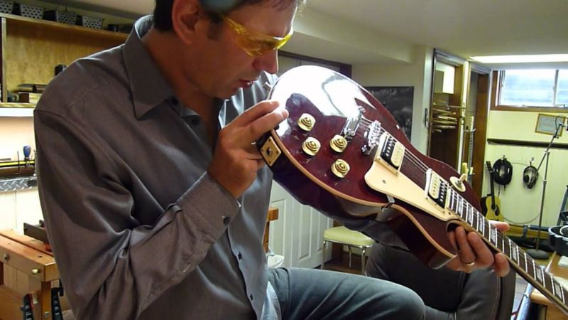 Quan sát cần đàn guitar điện bằng mắt thường để phát hiện cong vênh