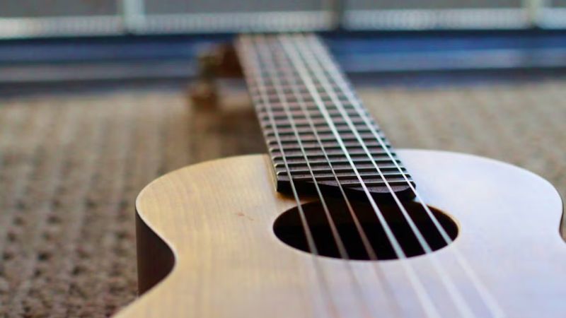 Quan sát tổng thể đàn Guitalele để phát hiện vết nứt, trầy xước hoặc hư hại bên ngoài