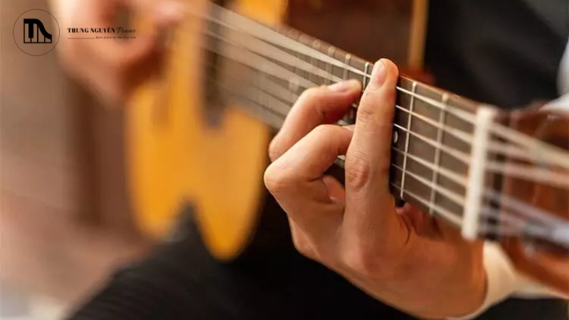 Đặt ngón tay cái ra sau giữa cần đàn để làm điểm tựa