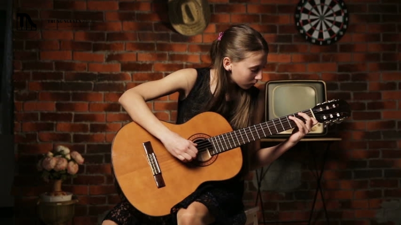 Nên học guitar đệm hát hay cổ điển: So sánh và lời khuyên A-Z 1 Cận cảnh bộ dây kim loại của guitar acoustic và bàn tay đang bấm một hợp âm