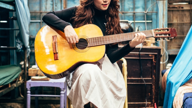 Ngồi thẳng lưng trên một chiếc ghế không có tay vịn.